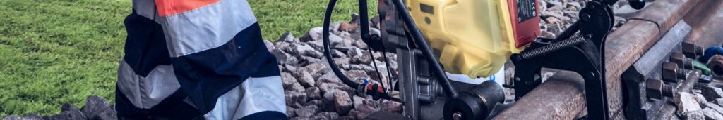 Cembre battery rail drill clamped to railway track